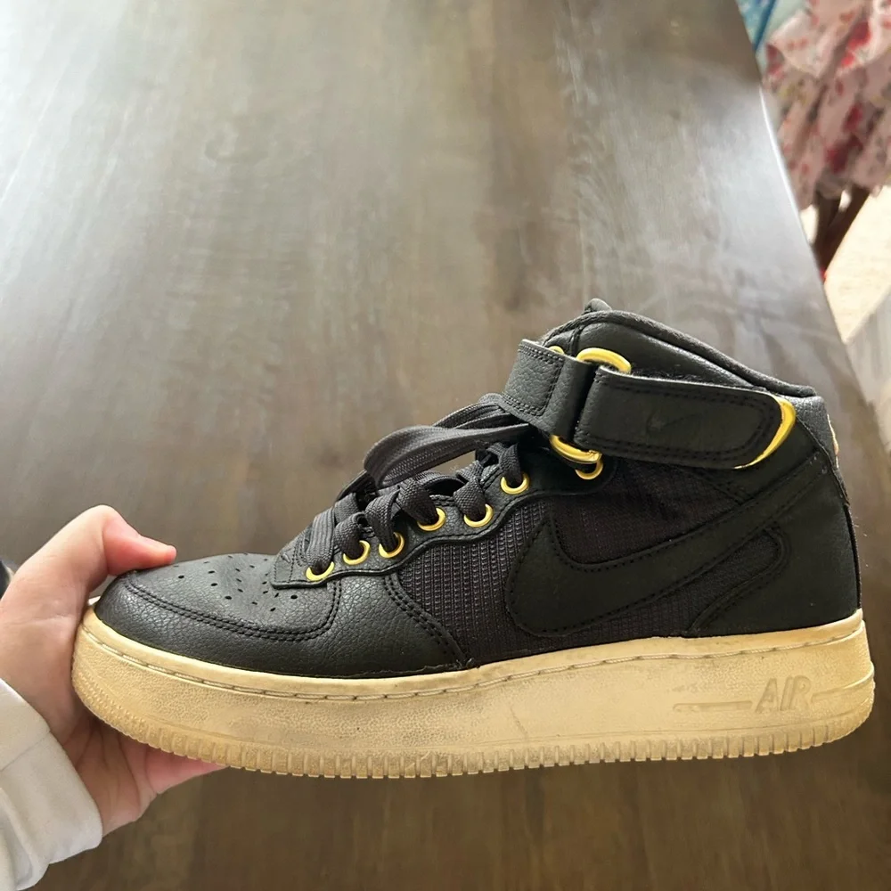 Nike Air Force ones black high top sneakers gold trim